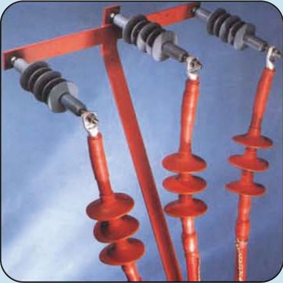 Three red heat-shrink outdoor terminations with rain sheds, mounted on a steel structure and connected to line insulators