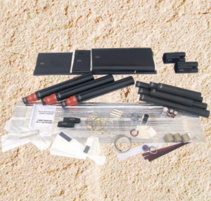 Contents of a GPS/2436 joint kit laid out: black heat-shrink tubes and sleeves, red-banded dual-wall tubes, connectors, mesh and tapes